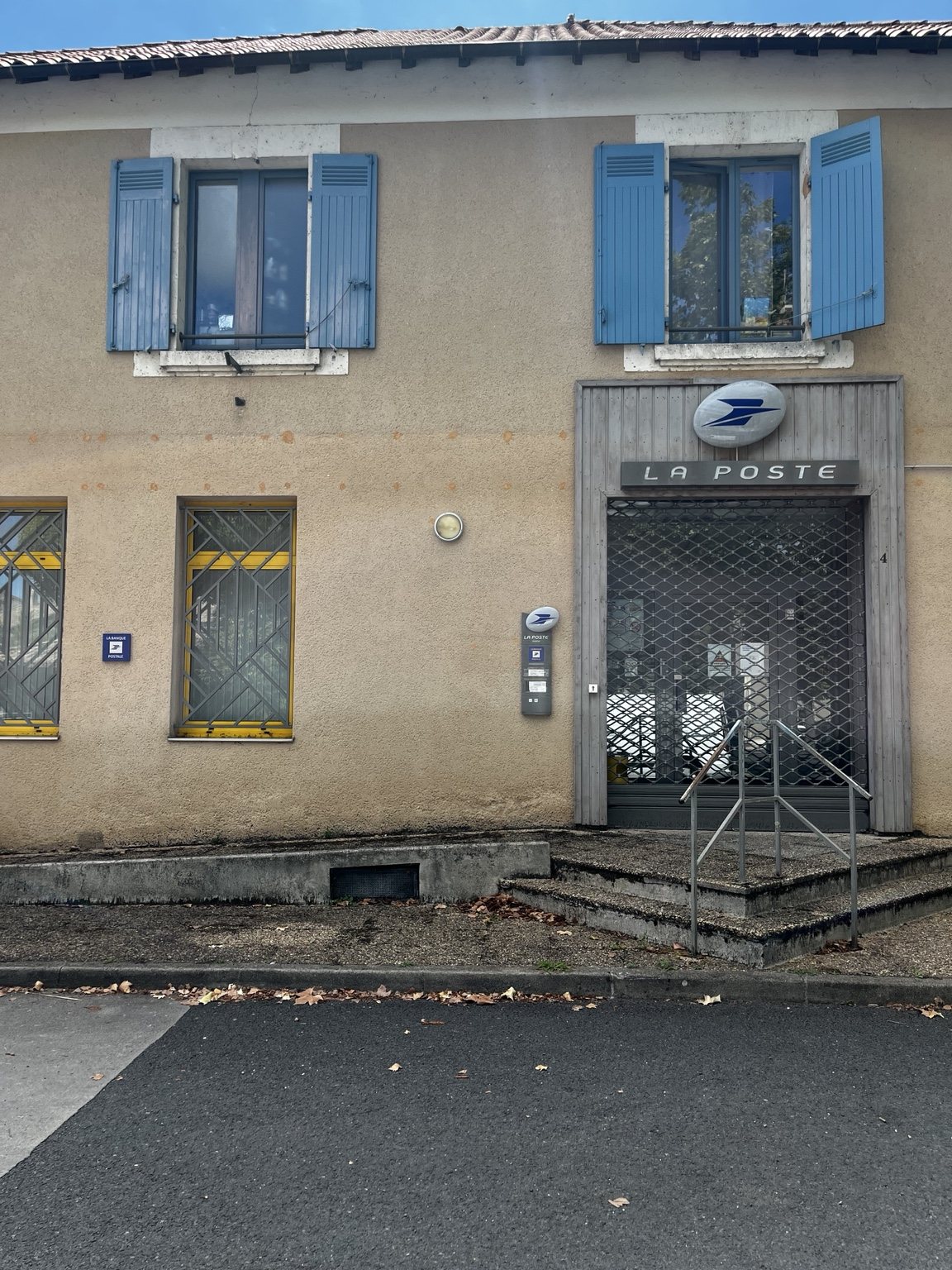A French La Poste branch with its metal security grille down and the entrance closed
